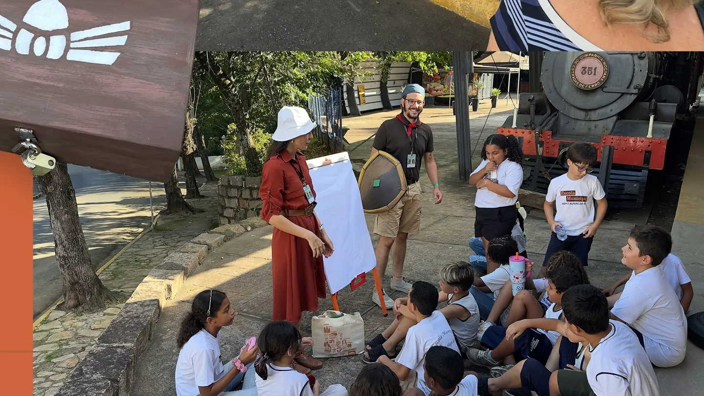 Crianças e educadores em atividade junto a uma locomotiva histórica